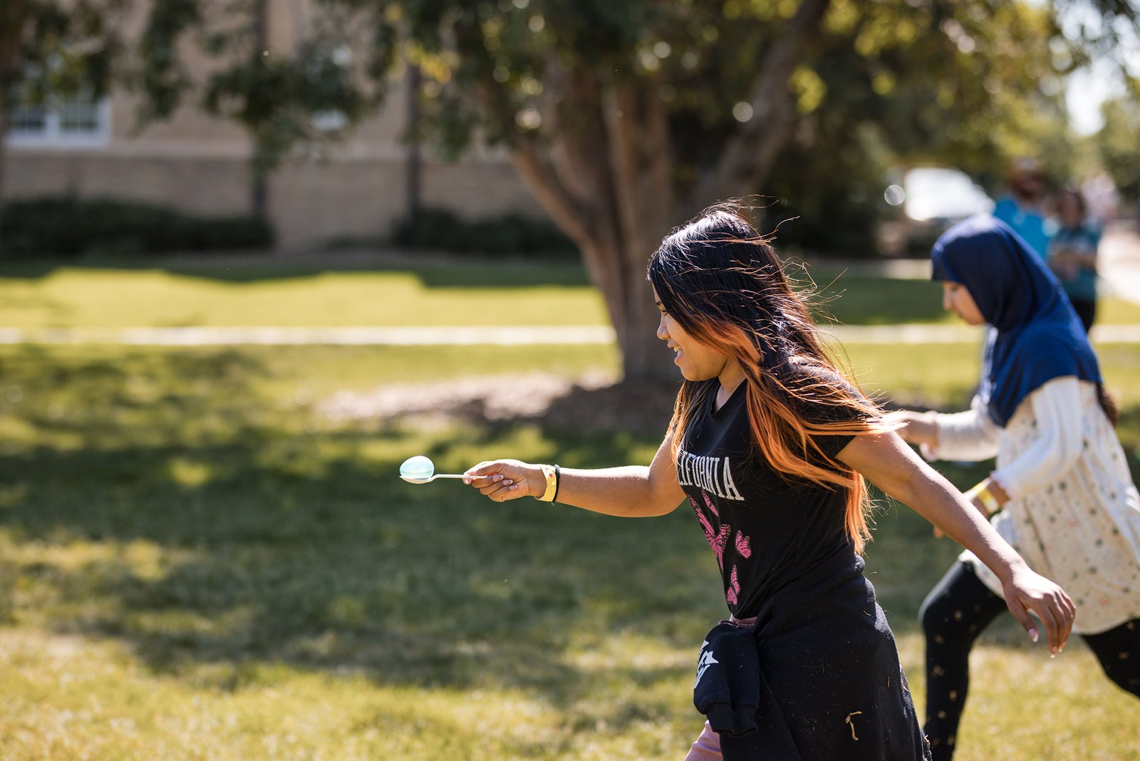 Girl running with spoon holding egg