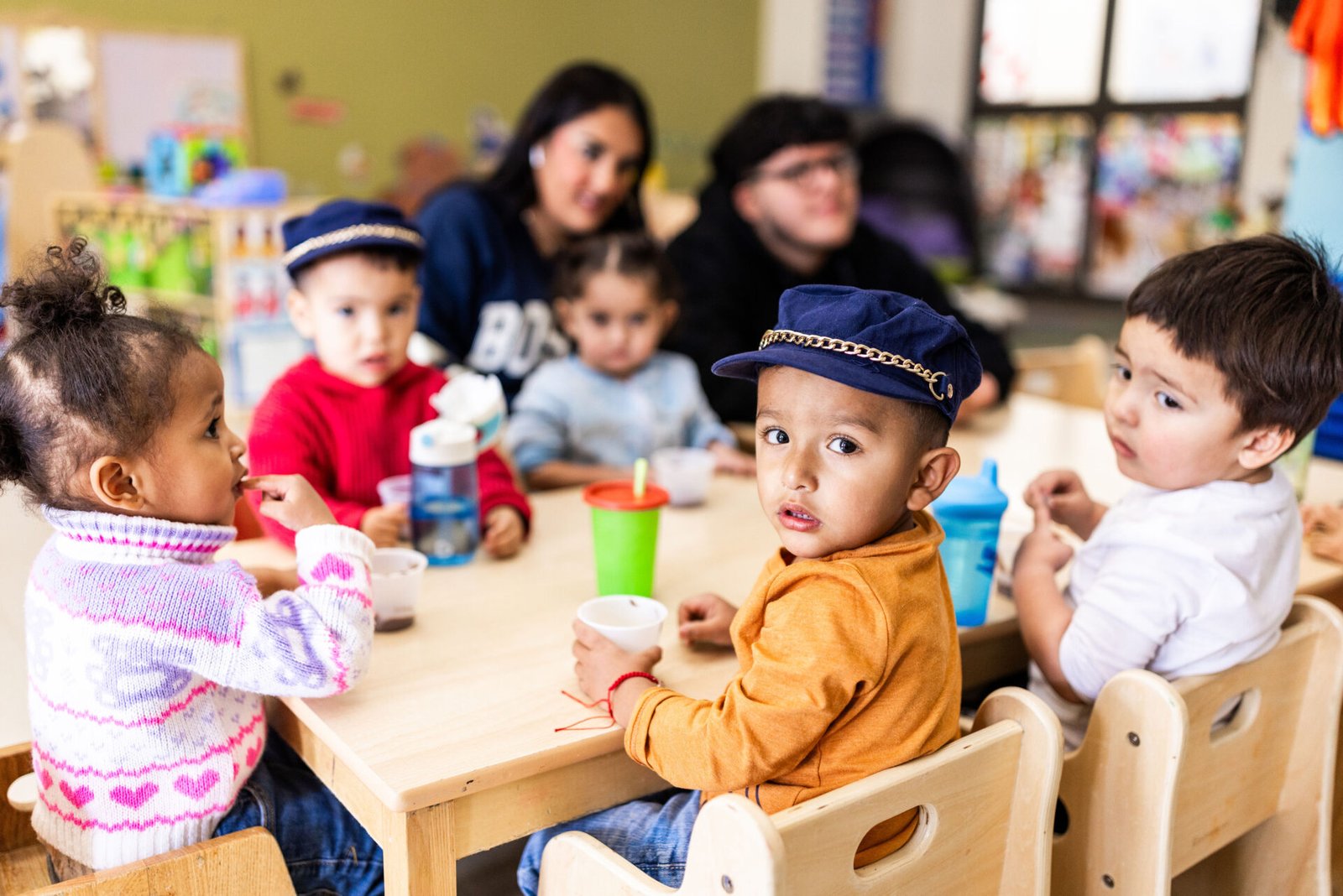 preschool children sitting at a table in a school