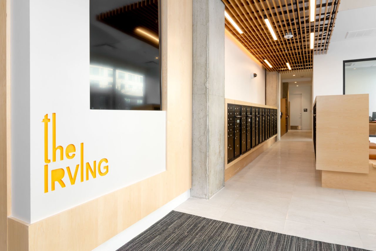 apartment lobby with The Irving written on the wall and a row of mailboxes